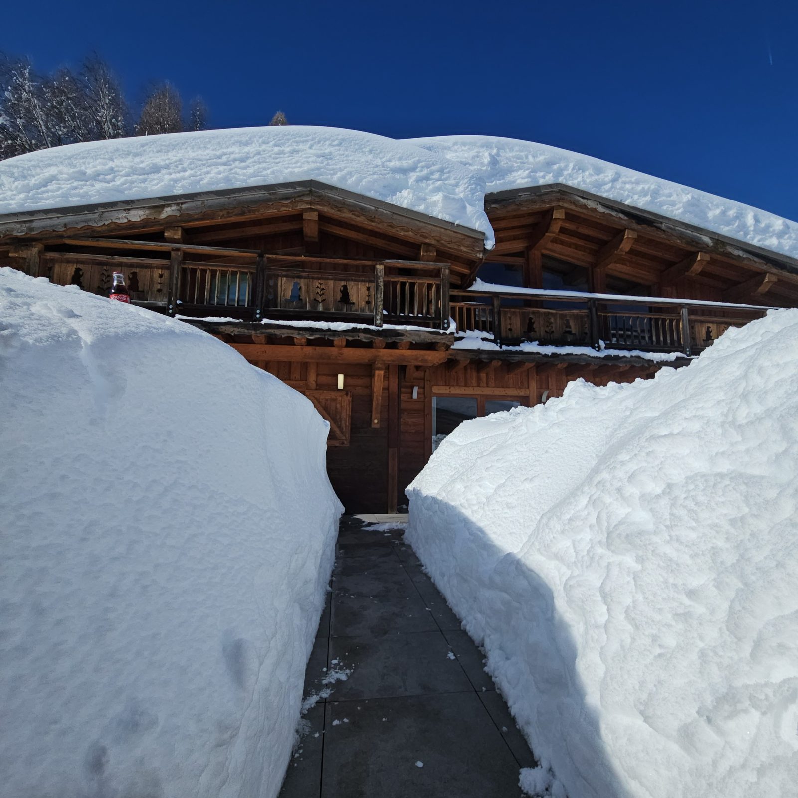 The path to the chalet door between two walls of snow